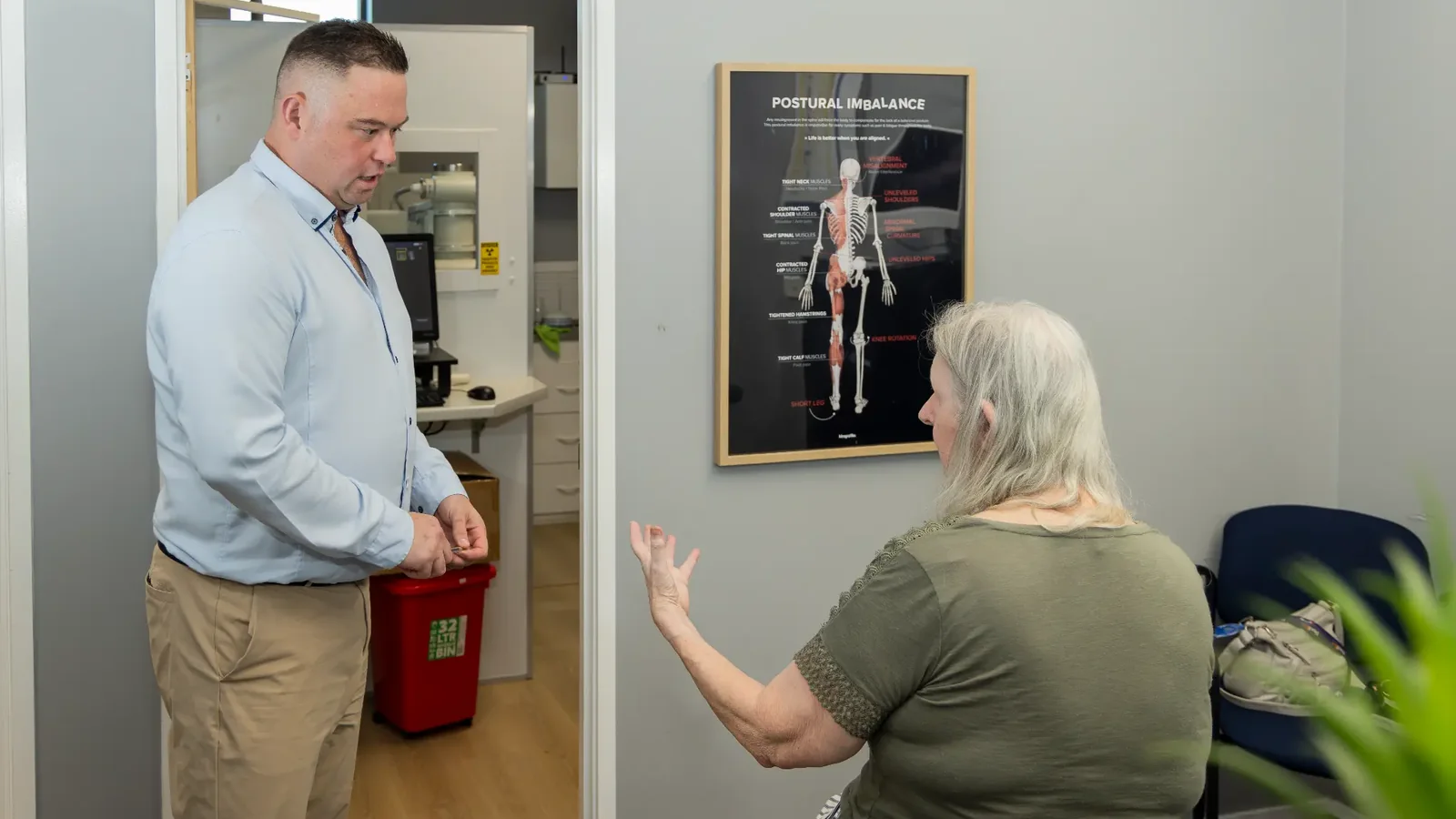 Dr Michael Charlton explaining the first-visit process with an adult patient at Charlton Chiropractic Redbank