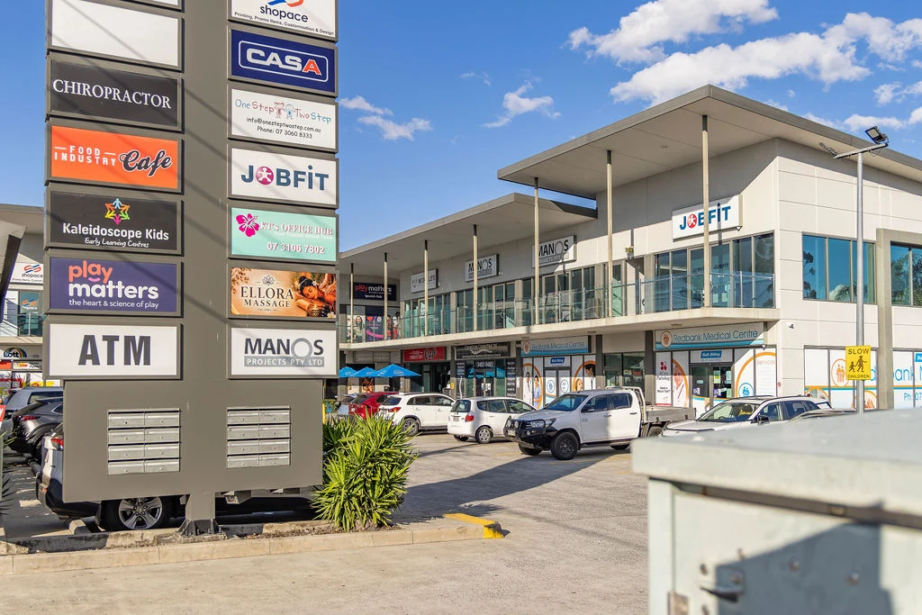 Charlton Chiropractic Redbank exterior, parking area and shopping-centre pylon sign on Brisbane Road